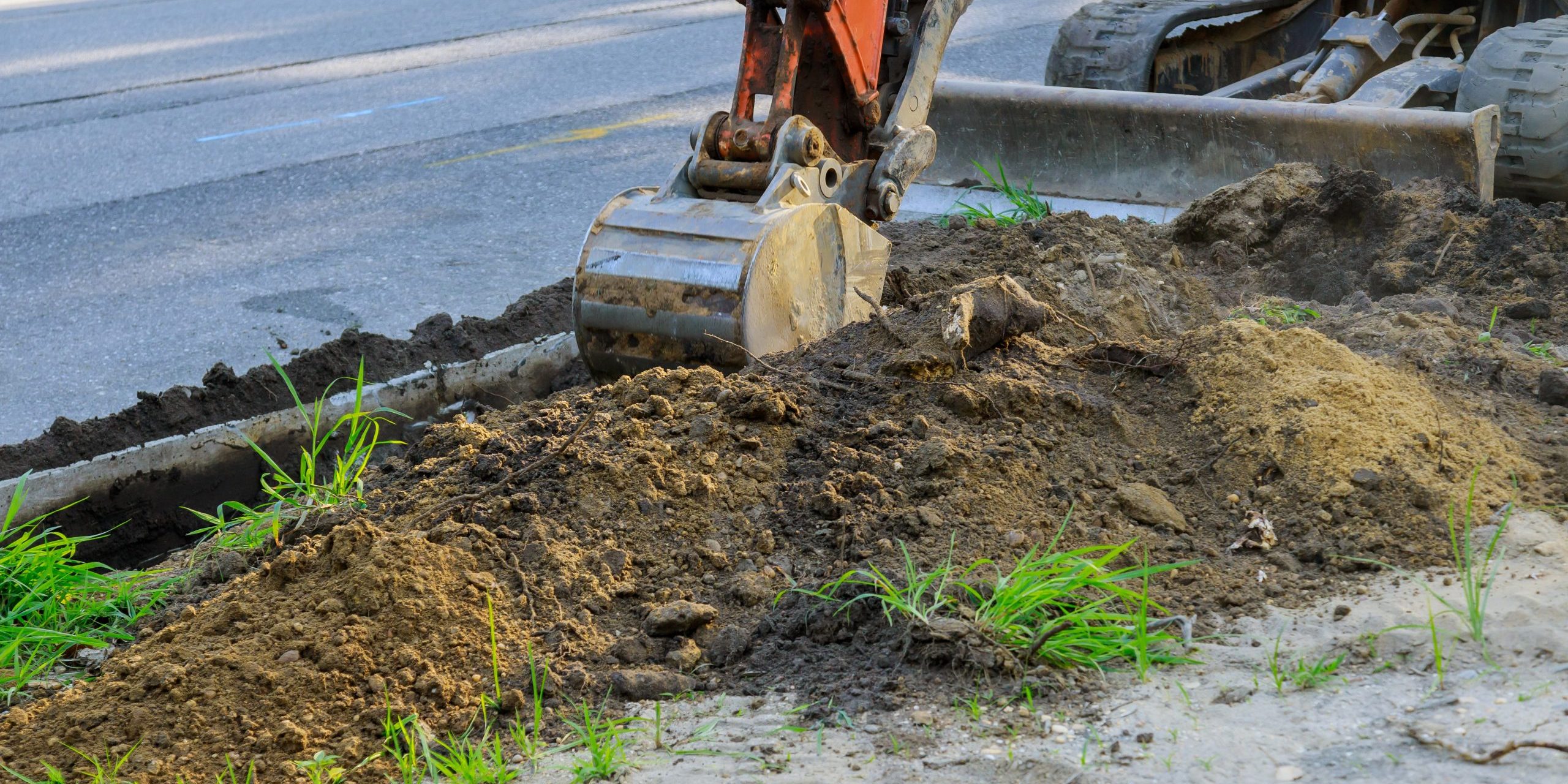 Backhoe on road work digger working at construction in excavation pit