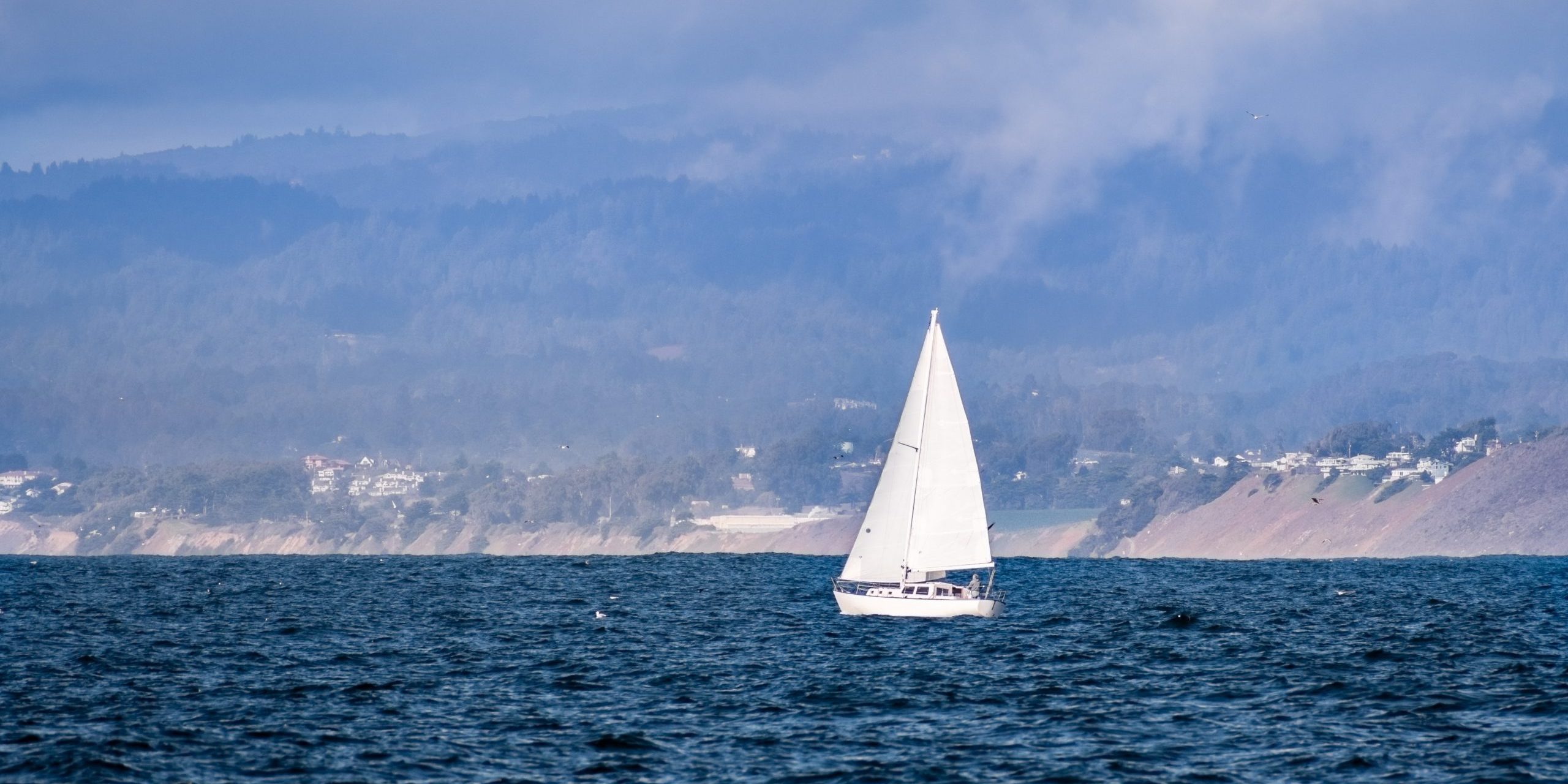 Sailboat close to the Pacific Ocean coastline near Moss Landing, Sailboat close to the Pacific Ocean coastline near Moss Landing, Monterey Bay, California