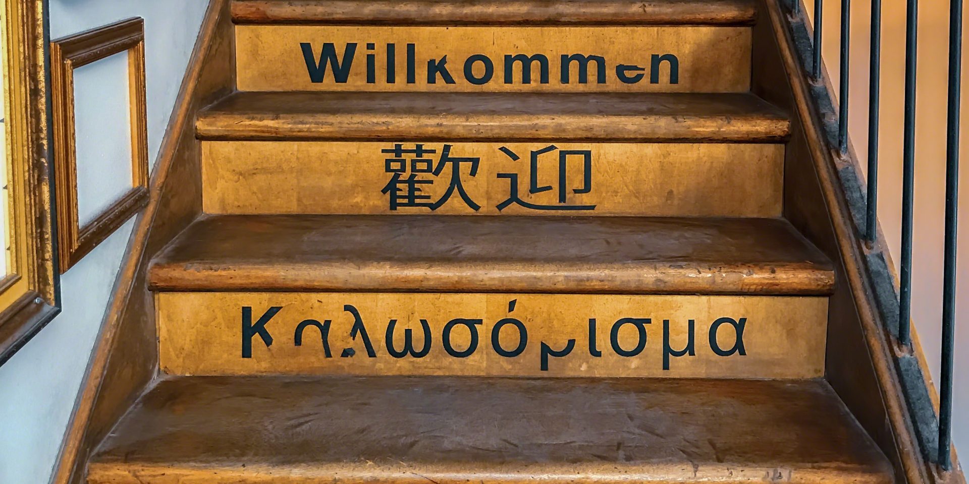 Old wooden staircase with the word welcome written on each step in various world languages