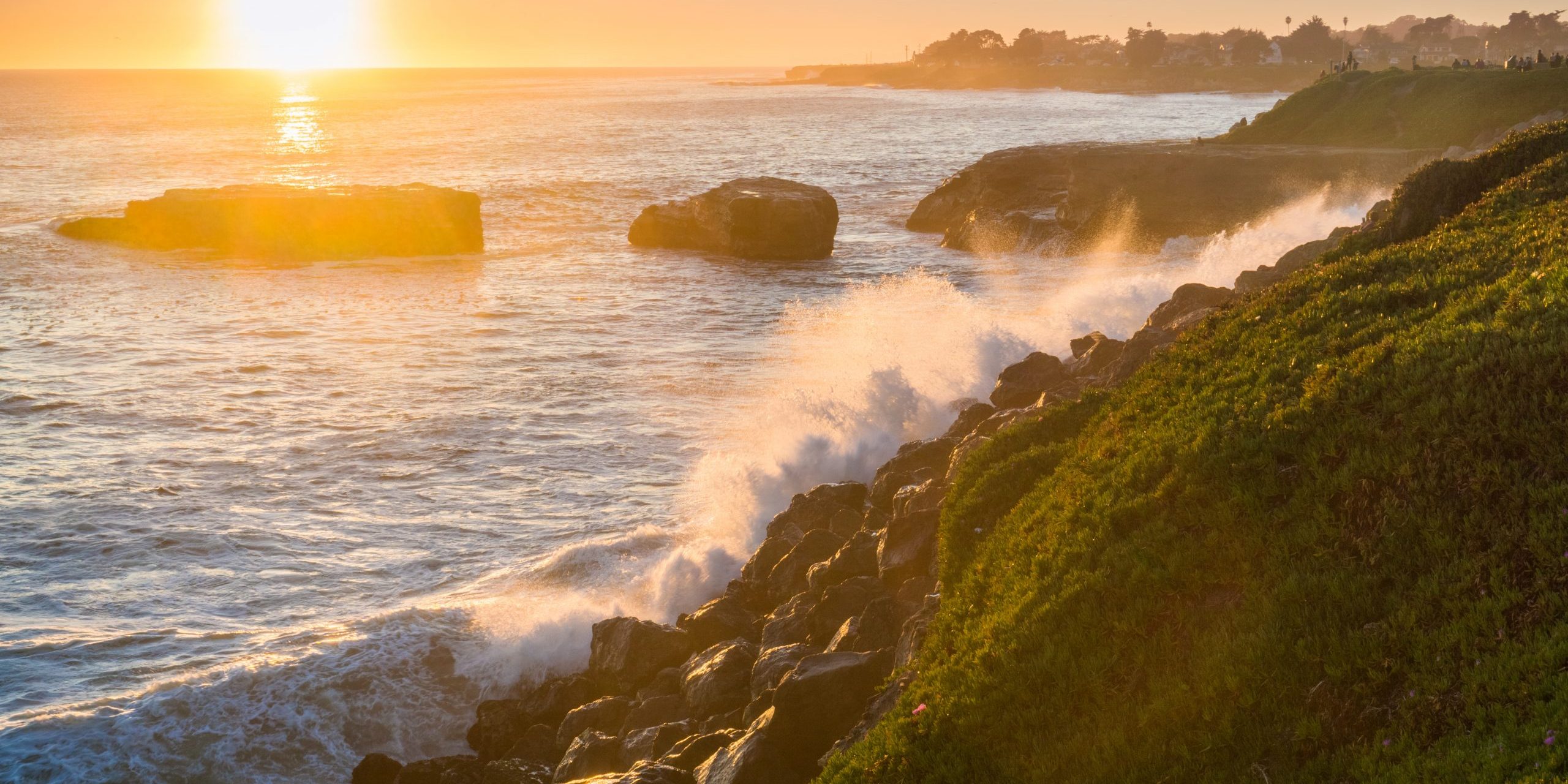 Waves crushing on the rocky shoreline at sunset, Santa Cruz, California